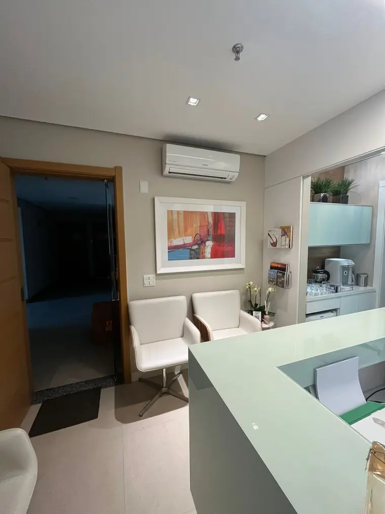 Balcão da recepção com quadro e poltronas