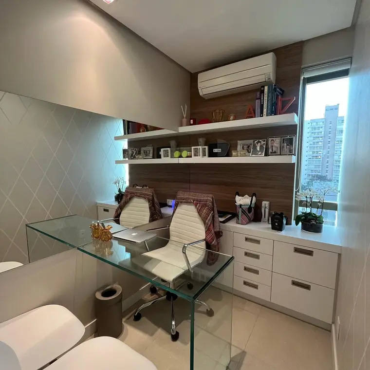 Sala de atendimento com mesa de vidro e estante de madeira